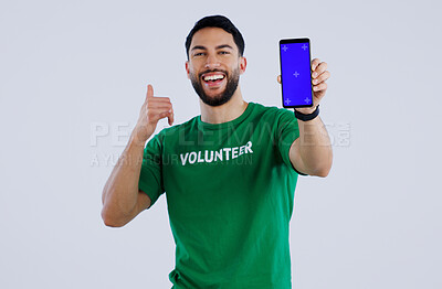 Buy stock photo Green screen, phone and thumbs up by volunteer man portrait in studio with news on grey background. Smartphone, space and face of male activist with thank you emoji for charity, donation or support