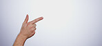 Hand, pointing and person in studio with mockup space for advertising, promotion or marketing. Finger, closeup and man model with show or presentation gesture for empty mock up by white background.