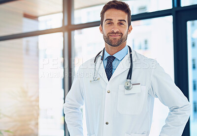 Buy stock photo Portrait of a confident young doctor posing with his hands on his hips in a hospital