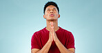 Religion, praying and young man in a studio for hope, gratitude and spiritual expression. Prayer, christian and male person from Mexico speaking for worship to god isolated by blue background.