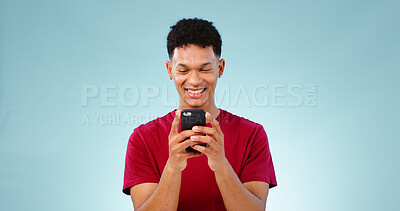 Buy stock photo Man, smile and texting on phone in studio for communication mock up on blue background. Young, person, model and Cape Town with mobile app, message or social media by internet, connection or cellular