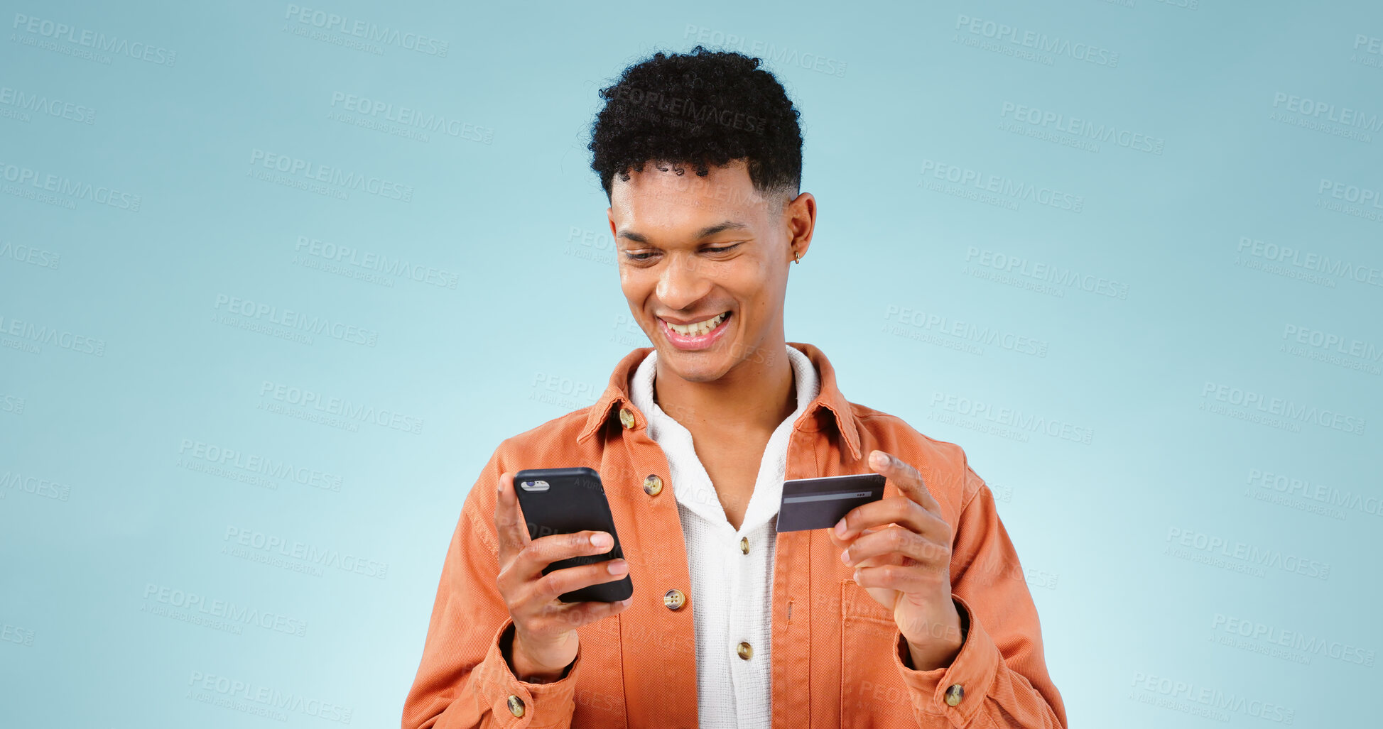 Buy stock photo Man, phone and credit card for online shopping, e commerce and digital money on a blue background. Happy student or young person with mobile app, internet banking or e learning registration in studio