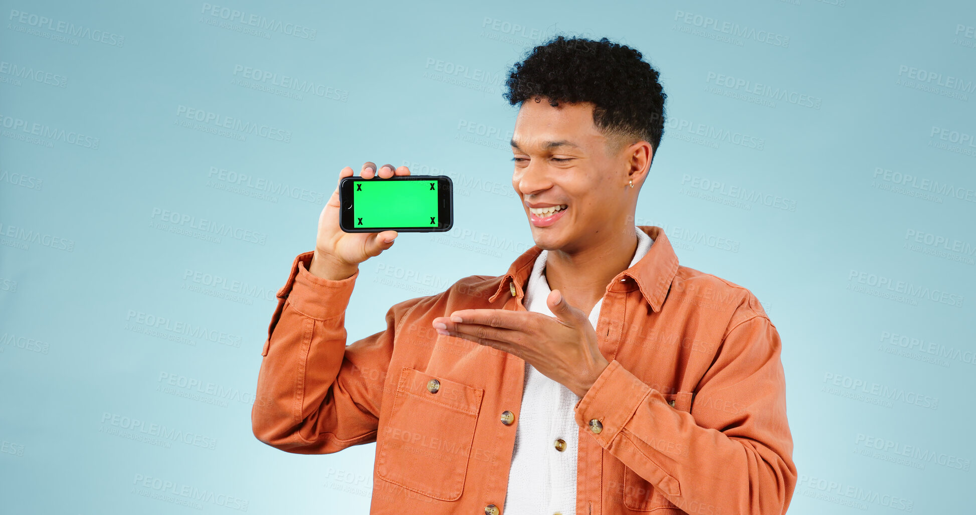 Buy stock photo Happy man, show and phone with greenscreen in studio for social media mock up on blue background. Male model, hand and mobile app in presentation or announcement online, deal or promotion by internet