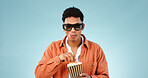 Man popcorn and studio with glasses for 3d movie with eating snack, streaming or cinema by blue background. Person, sunglasses and corn fast food to watch fantasy show, cartoon or film in theater