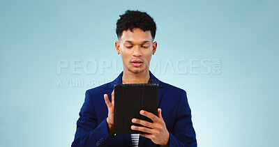 Buy stock photo Man in studio, typing on tablet for business ideas and research for creative startup schedule. Thinking, agenda and professional person with digital app, scroll and social media on blue background.