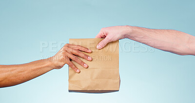 Buy stock photo Hands, paper bag and delivery in studio closeup for fast food, supply chain and cargo by blue background. Courier, logistics and package for service, shipping and giving to customer for e commerce