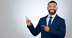 Portrait, pointing and corporate businessman in studio with smile, deal announcement and mockup space. News, advice and happy man with choice, presentation or offer notification on white background.