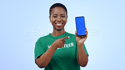 Buy stock photo Woman, volunteering and point at phone with green screen in portrait for mockup on blue background in studio. Black person, happy or smile for internet, cellular or network for homepage on mobile app