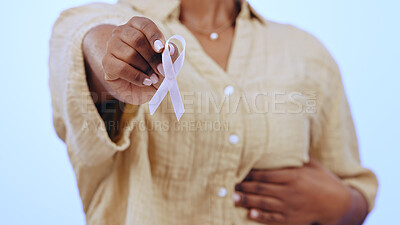 Buy stock photo Support, breast cancer and hand of woman with sign, badge or ribbon in studio or blue background. Icon, symbol and person in rehabilitation with healthcare, awareness and show pink bow for solidarity