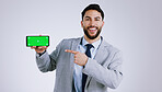 Business man, mobile green screen and presentation for social media, career software or job registration in studio. Portrait of corporate worker pointing to phone app or mockup on a white background