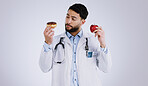 Doctor, apple or donut for choice in health for nutrition in studio on white background for mock up. Man, male model or medical professional with thinking of diet, food or offer for eating in Mexico