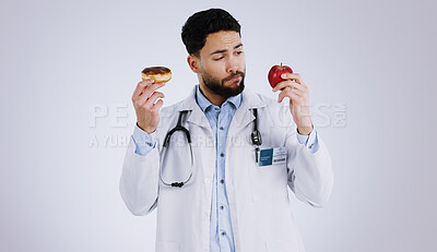 Buy stock photo Healthy, diet and doctor with choice of food, apple or donut  in hands for nutrition in studio white background. Nutritionist, thinking and man with a decision for health with fruit and dessert