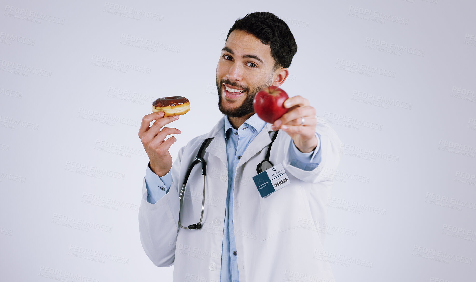 Buy stock photo Man, doctor and smile for apple in portrait, choice and donut or snack options in studio mockup. Happy person, nutritionist and healthy food or approval, advice and opinion or diet by gray background