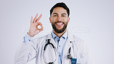 Buy stock photo Happy man, portrait and doctor with OK sign for healthcare approval against a gray studio background. Face of male person or medical professional smile with like emoji, okay or yes for perfect health