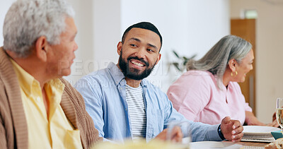 Buy stock photo Family, food and smile the dinner table with a man taking to his senior father while eating a meal together. Feast, conversation and festive celebration with a group of people chatting in a home