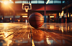 Basketball, indoor and court with ball on floor for athletic competition, fitness and recreation low angle. Exercise, cardio and texture of sports equipment for training, match and workout at sunset.