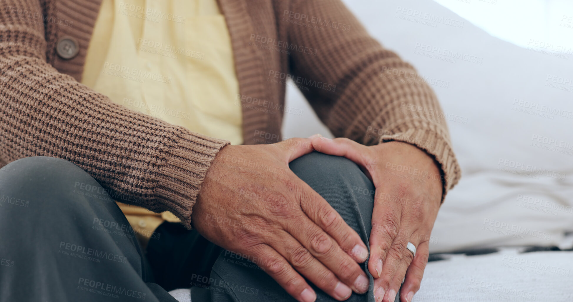 Buy stock photo Hands, knee pain and senior man on a sofa with arthritis, fibromyalgia or osteoporosis closeup. Legs, problem and zoom of elderly person with massage for relief from inflammation, injury or joint