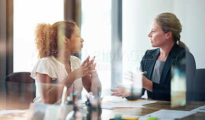 Buy stock photo Shot of two businesswoman sitting in an office talking together