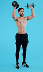 Fitness, dumbbells and man stretching in studio for training, exercise or bodybuilding on blue background. Health, wellness and bodybuilder with bicep workout, muscle or flex, progress or resilience