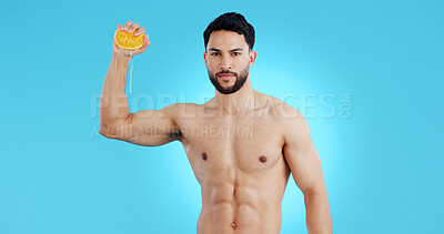 Buy stock photo Orange, splash and portrait of man in studio for vitamin C, natural cosmetics or healthy diet on blue background. Fruit, squeeze or model face with citrus, juice or  skin detox, wellness or nutrition