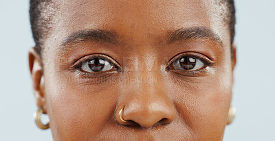 Buy stock photo Eyes, looking and portrait of black woman in studio for vision, eyesight and focus on blue background. Healthcare, optometry and isolated face closeup of person with cosmetics, wellness and eye care