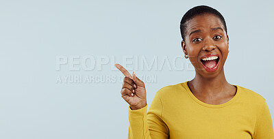 Buy stock photo Happy black woman, portrait and pointing in surprise for advertising or marketing against a gray studio background. African female person smile in wow for deal promotion, sale or discount on mockup