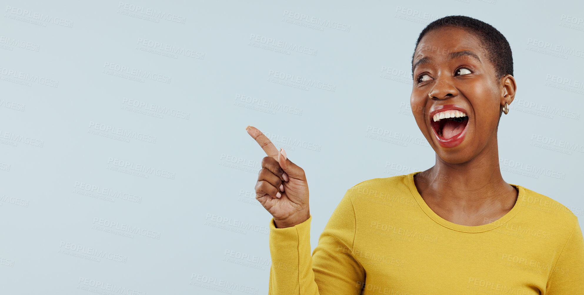 Buy stock photo Happy black woman, pointing and surprise for advertising or marketing against a gray studio background. Face of excited African female person smile in wow deal, sale promotion or discount on mockup