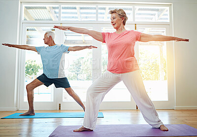 Buy stock photo Full length shot of a senior couple practicing yoga in their home