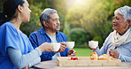 Nurse, coffee and breakfast for elderly care, retirement or healthcare support at park or nature. Doctor with senior man and woman for tea, meal or outdoor snack together in health and wellness