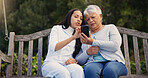 Phone, senior or mother with woman on bench in nature reading news on social media in retirement. Online gossip, mature parent or daughter for together in park or garden as a family with mobile app