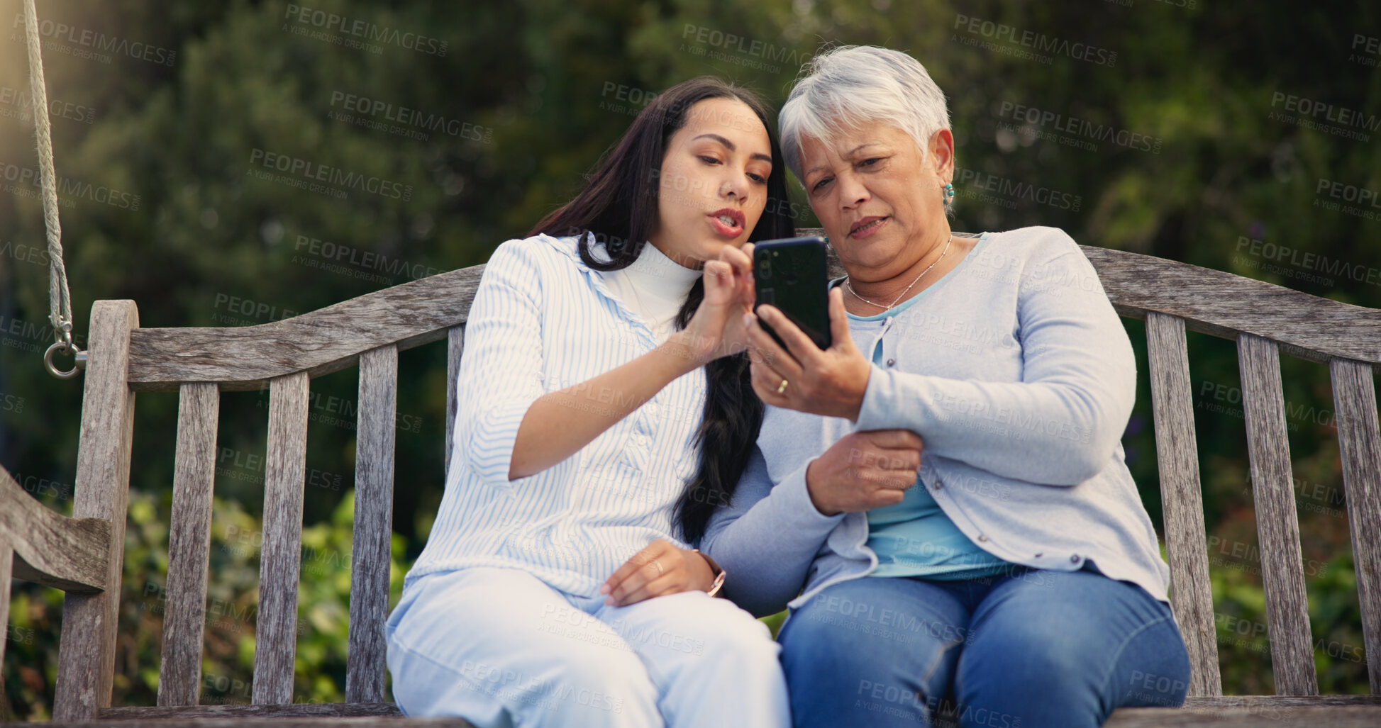 Buy stock photo Phone, senior or mother with woman on bench in nature reading news on social media in retirement. Online gossip, mature parent or daughter for together in park or garden as a family with mobile app