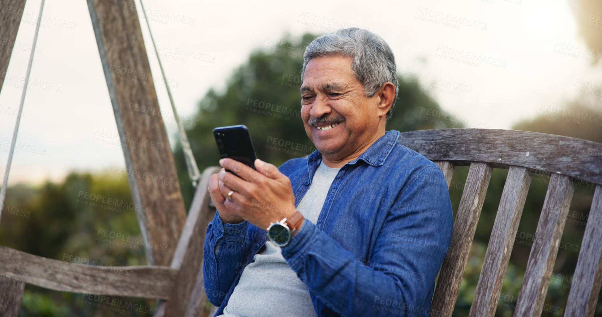 Buy stock photo Senior man, happy and smartphone on bench for communication, connection and social media in park. Mature pensioner, smile and technology for lounge in nature, digital games and wellness on retirement