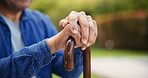Senior, person or hands with closeup of walking stick for mobility support, balance or alzheimer in park. Elderly, man or cane outdoor in nature for healthcare, arthritis or rehabilitation for health