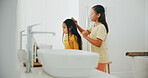 Family, bathroom and a sister brushing the hair of her sister in their home for morning routine or care. Kids, beauty or haircare with a young girl child and sibling in their apartment for hygiene