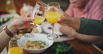 Lunch. closeup and people with juice, cheers and dining room with fruit beverage, relax and wellness. Family, home and hands juice with health, nutrition meal and toast with celebrate and relaxing