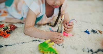 Buy stock photo Girl child, dinosaur toys and floor with playing, development and relax with game in room at family house. Kid, plastic reptile and carpet with hands, flooring or animal for fantasy, learning or home