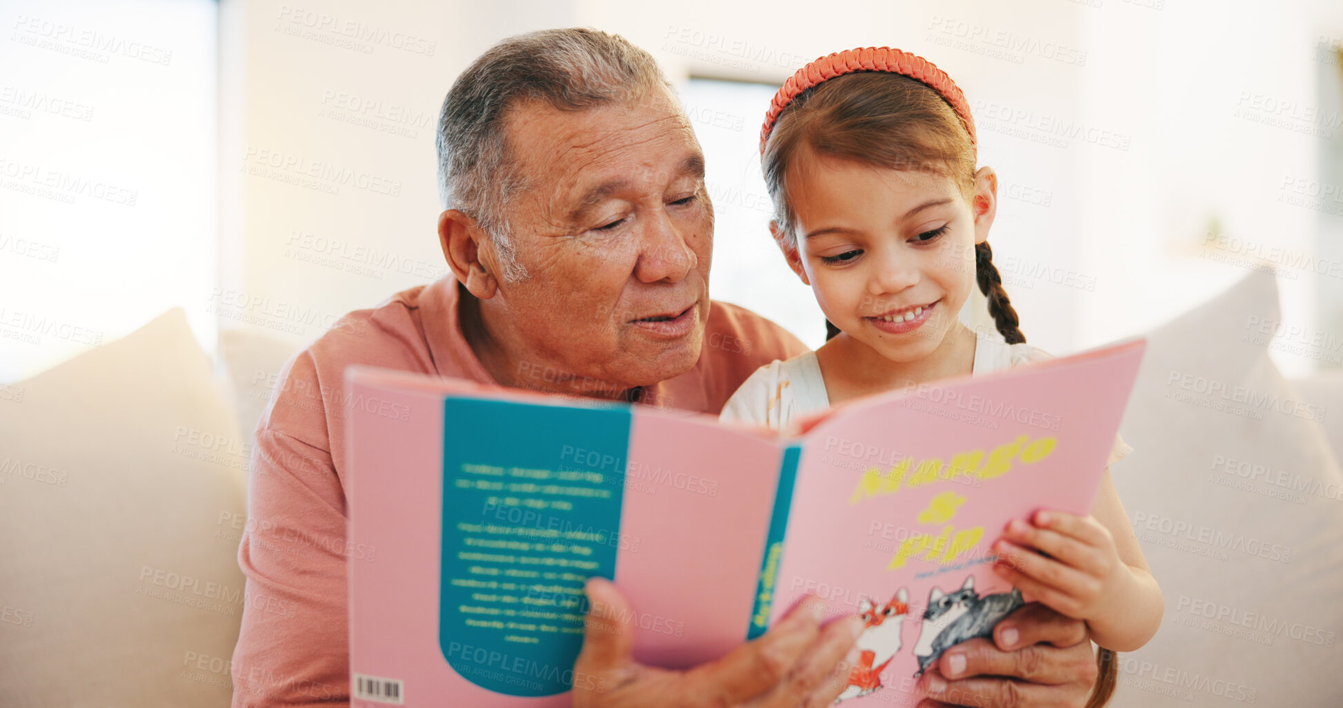 Buy stock photo Grandfather, child and reading book on sofa for literature, education or bonding together at home. Grandparent with little girl or kid smile for story, learning or relax on living room couch at house