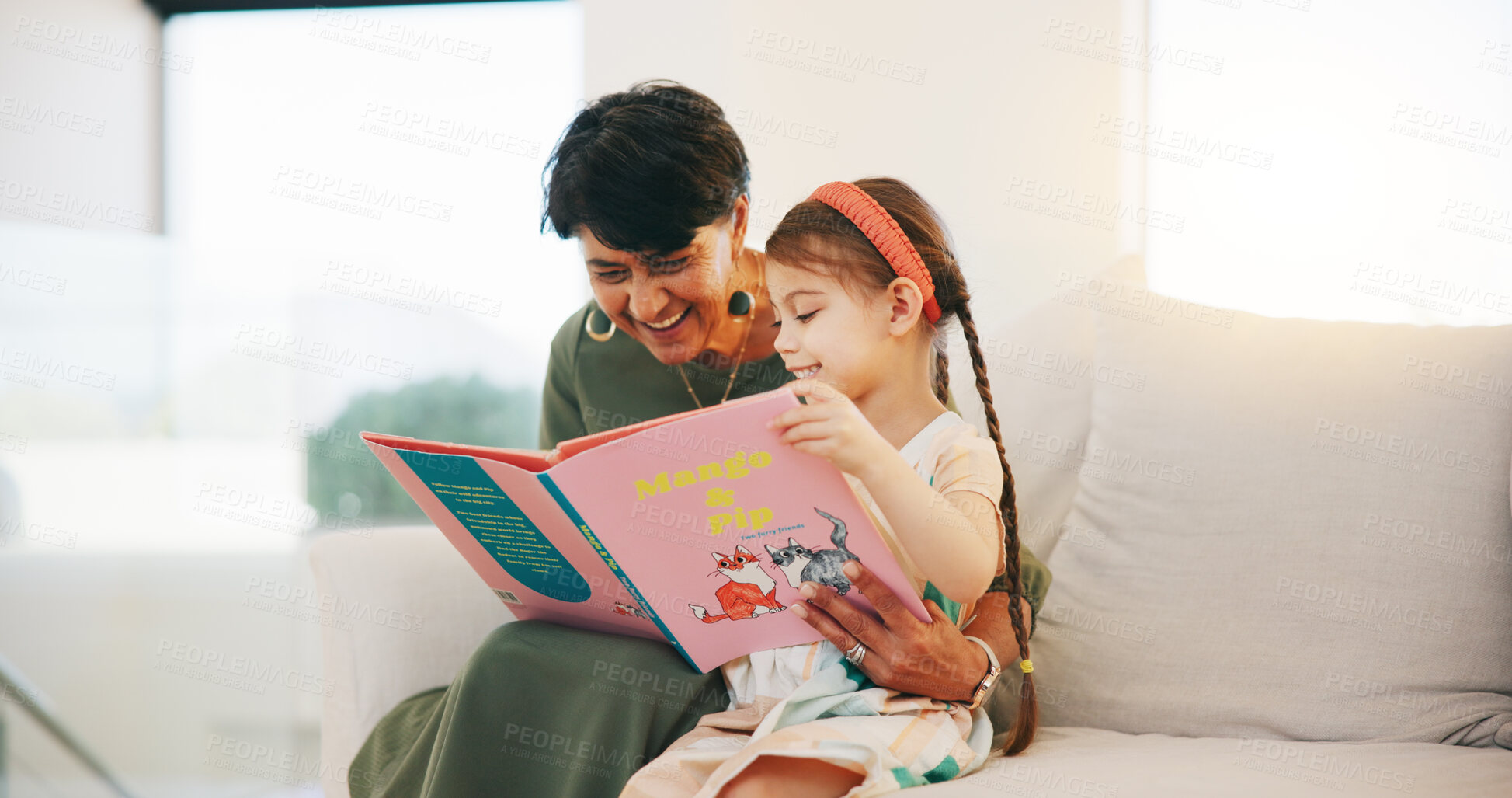 Buy stock photo Happy grandmother, child and reading book on sofa for literature, education or bonding together at home. Grandparent with little girl smile for story, learning or relax on living room couch at house