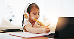 Girl, headphones and writing in book for elearning, education or study on desk at home. Female person, little child or kid taking notes with tablet, headset or technology for virtual class at house