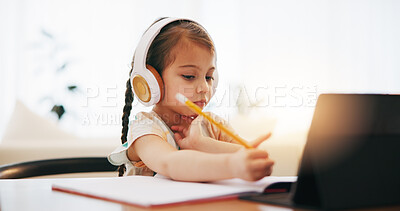 Buy stock photo Girl, headphones and writing in book for elearning, education or study on desk at home. Female person, little child or kid taking notes with tablet, headset or technology for virtual class at house