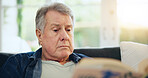 Face, senior and man for reading in living room with closeup on sofa for peaceful, calmness or relaxing. Elderly person, alone and retirement with book for thinking, information or knowledge in home
