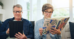 Senior couple, reading book and tablet on sofa in home, relax and internet search on social media. Elderly man, woman and technology, knowledge and information in living room in retirement together