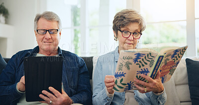 Buy stock photo Senior couple, reading book and tablet on sofa in home, relax and internet search on social media. Elderly man, woman and technology, knowledge and information in living room in retirement together