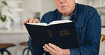 Reading, Bible and hands of old man in home with Christian worship, prayer or education in faith. Elderly, person or studying holy gospel, religion or trust in God or spiritual learning in retirement