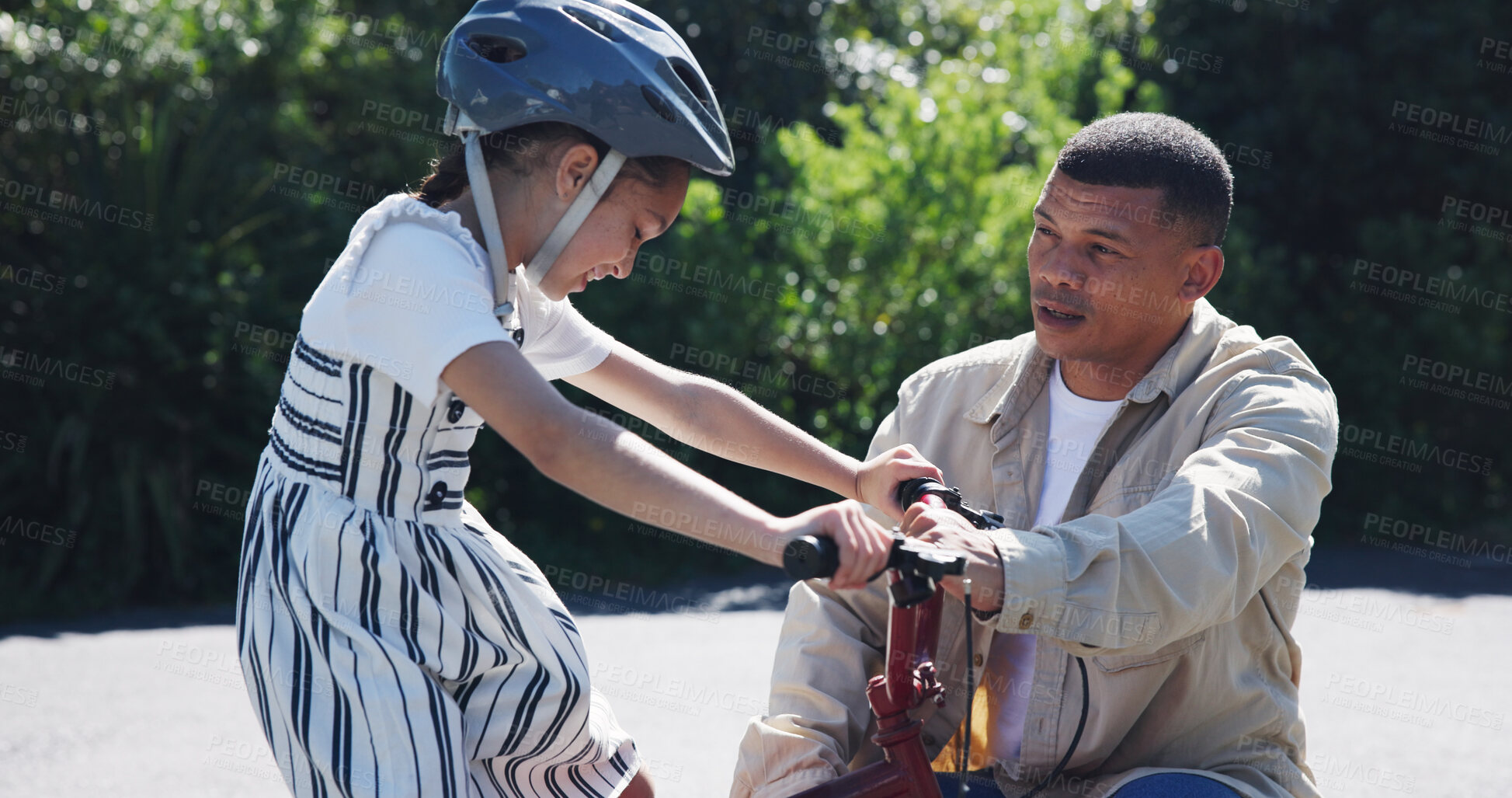 Buy stock photo Bike, learning and child or help from dad, teaching and cycling in neighbourhood, helmet and safety. Daughter, father and support or fun, skill development and growth on road, trust and outdoors