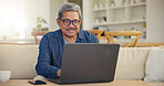 Elderly, man and smile for laptop living room on sofa for typing, email or message for communication. Senior person, looking at screen and glasses with technology, internet or web for work from home