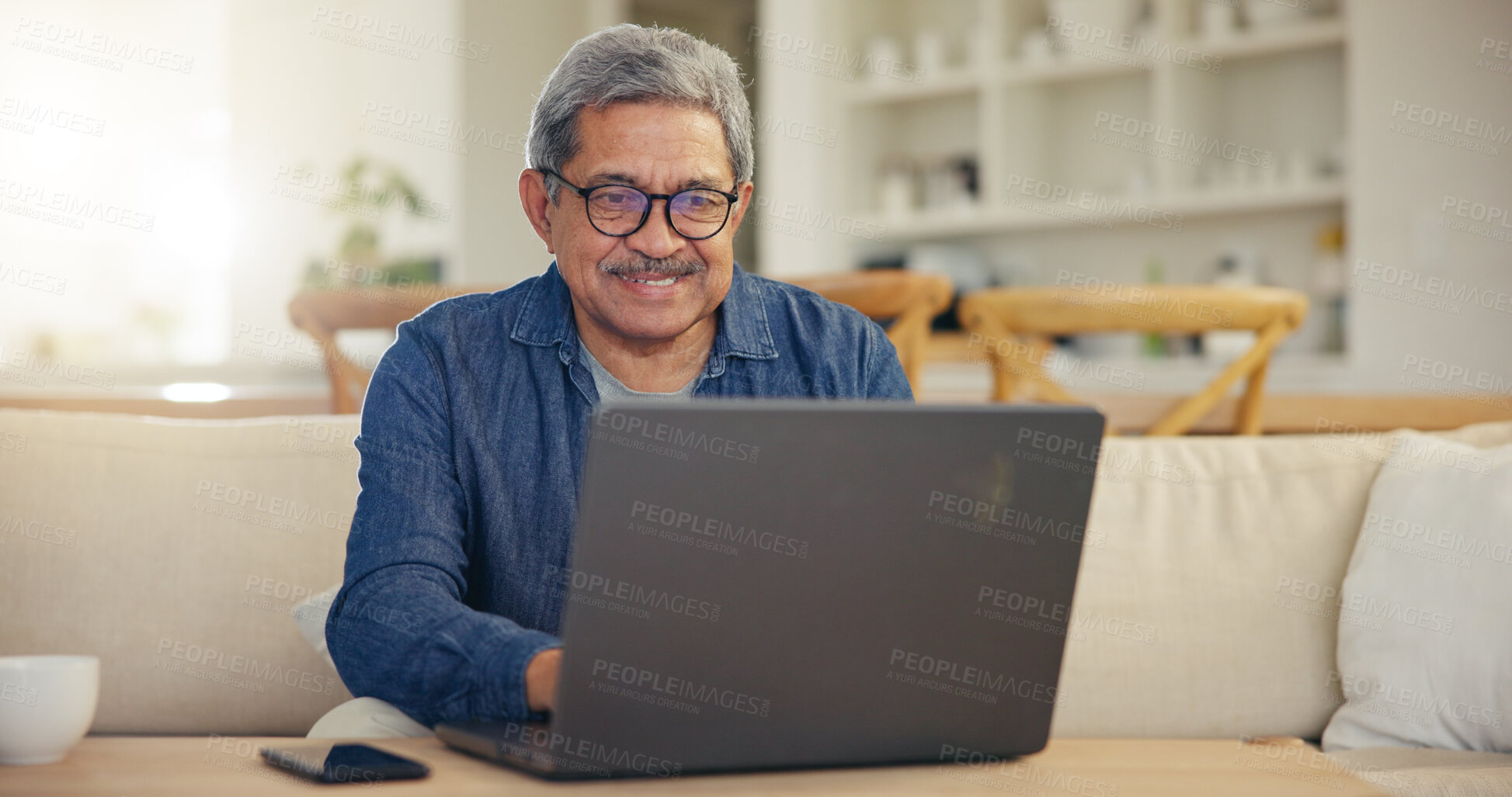 Buy stock photo Elderly, man and smile for laptop living room on sofa for typing, email or message for communication. Senior person, looking at screen and glasses with technology, internet or web for work from home