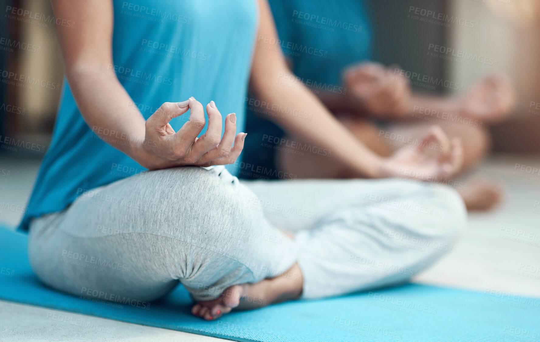 Buy stock photo Shot of a unrecognizable woman engaging in a seated yoga pose with her legs crossed