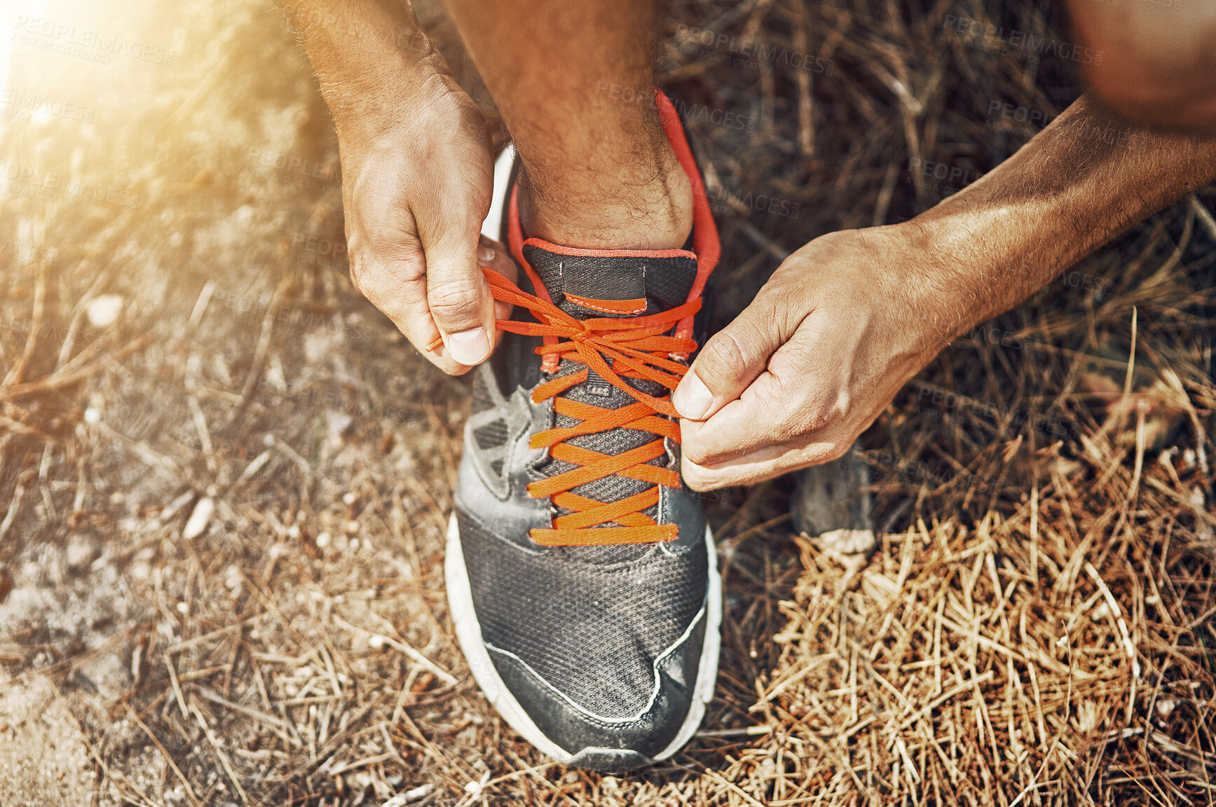 Buy stock photo Shot of a young person tying their shoelaces before going for a run outdoors