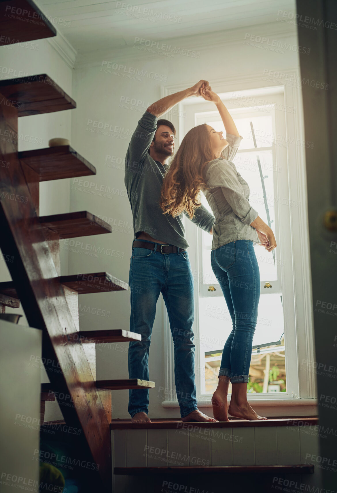 Buy stock photo Love, couple and dancing in home, bonding and having fun together for romance. Dance, happy and man and woman, funny and care, affection and enjoying quality time by stairs to relax on anniversary.